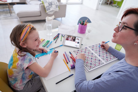 Mother and little daughter  playing together  drawing creative artwork during coronavirus quarantine