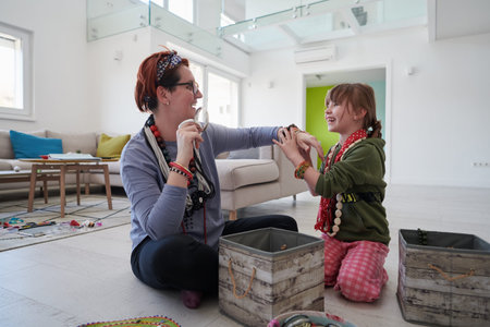 Mother and little girl daughter playing with jewelry while staying at home in coronavirus quarantineの写真素材