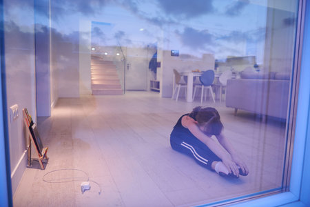Little girl have online training while watching the tablet and doing fitness and modern ballet dance...