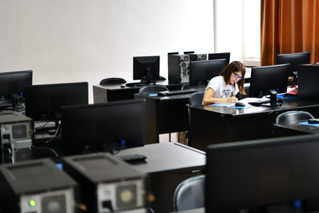 Only one female student in computers and  technology classroom working and learning concept of...