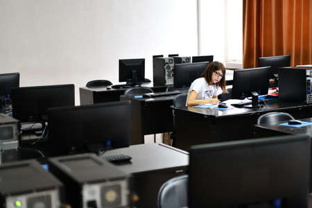 Only one female student in computers and  technology classroom working and learning concept of persistenceの写真素材