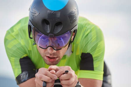 triathlon athlete riding professional racing bike at workout on curvy country roadの写真素材