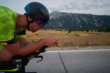 triathlon athlete riding professional racing bike at workout on curvy country roadの写真素材
