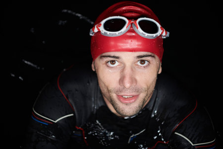 authentic triathlete swimmer having a break during hard training on night
