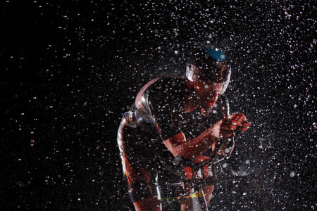 triathlon athlete riding bike fast on rainy night
