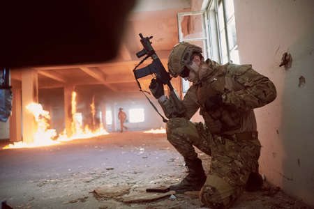 soldier in action near window changing magazine and take coverの写真素材