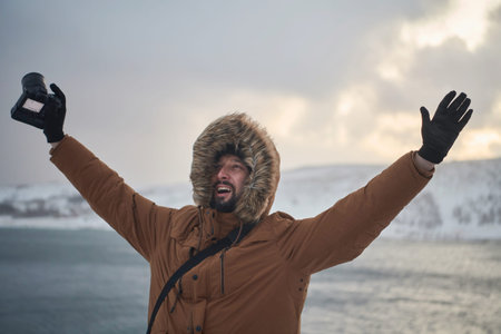 photographer at winter in stormy weather wearing warm fur jacketの写真素材