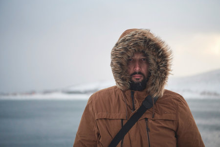 man at winter in stormy weather wearing warm fur jacketの写真素材