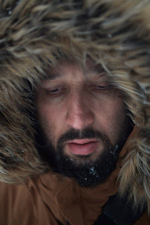 man at winter in stormy weather wearing warm fur jacketの写真素材