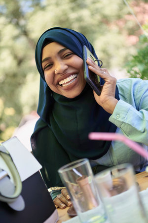 african woman using smartphone wearing traditional islamic clothesの写真素材