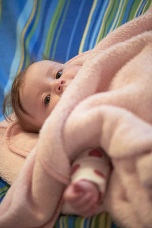 cute little baby in bed trying to sleepの写真素材