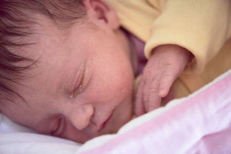newborn baby sleeping in bed at hospitalの写真素材