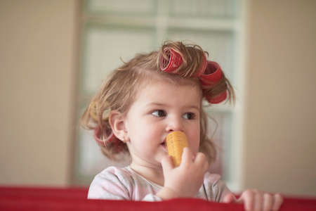 little baby girl with strange hairstyle and curlersの写真素材