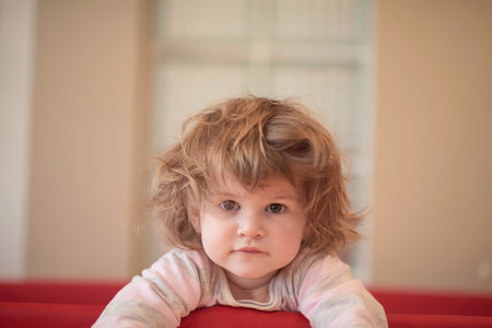 little baby girl with strange hairstyle and curlersの写真素材