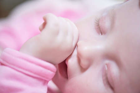 newborn baby sleeping at home in bedの写真素材