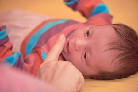 One month newborn baby sleeping in bedの写真素材