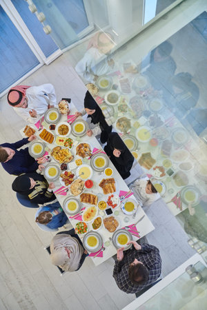 Top view of Muslim family making iftar dua to break fasting during Ramadan.