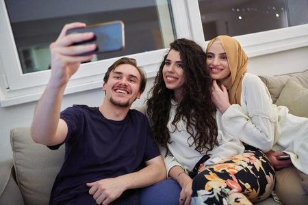 Young happy, muslims taking selfie in house