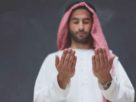 Arab man in traditional clothes praying to God or making duaの写真素材