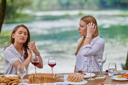 girlfriends having picnic french dinner party outdoorの写真素材