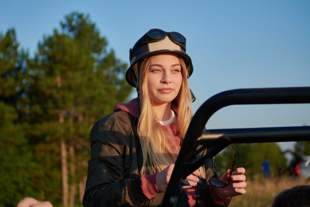 girl wearing a helmet and enjoying a buggy car ride on a mountainの写真素材