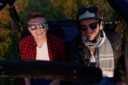 two young happy excited men enjoying beautiful sunny day while driving a off road buggy carの写真素材