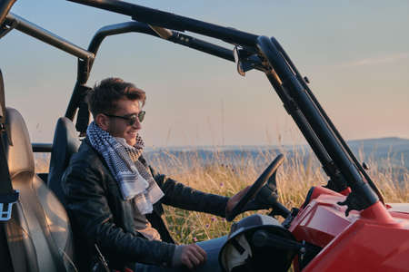 man enjoying beautiful sunny day while driving a off road buggy carの写真素材