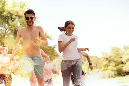 group of happy friends having fun on riverの写真素材