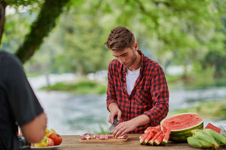 man cooking tasty food for french dinner partyの写真素材