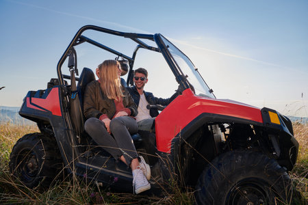 couple enjoying beautiful sunny day while driving a off road buggy