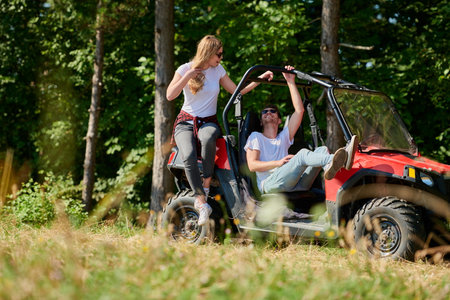 couple enjoying beautiful sunny day while driving a off road buggyの写真素材