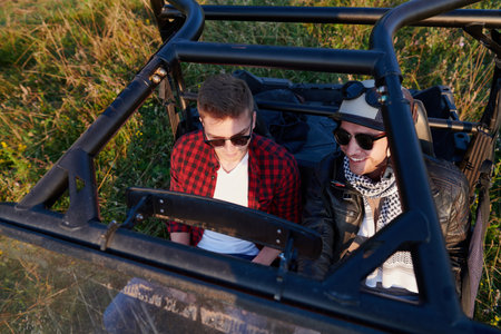 two young happy excited men enjoying beautiful sunny day while driving a off road buggy carの写真素材