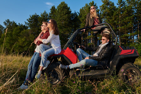 group young happy people enjoying beautiful sunny day while driving a off road buggy carの写真素材