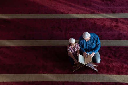 father and son reading holly book quran together islamic education conceptの写真素材