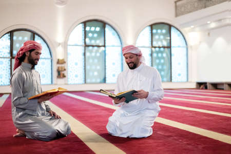 two muslim people in mosque reading quran together concept of islamic educationの写真素材