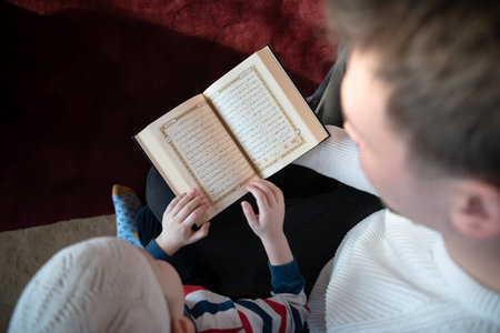 father and son in mosque praying and reading holly book quran together islamic education concept