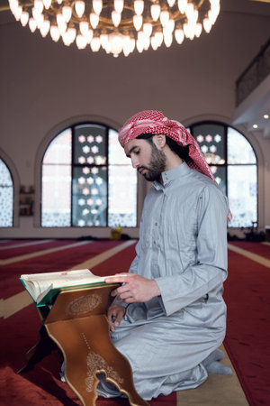 muslim man praying Allah alone inside the mosque and reading islamic holly book