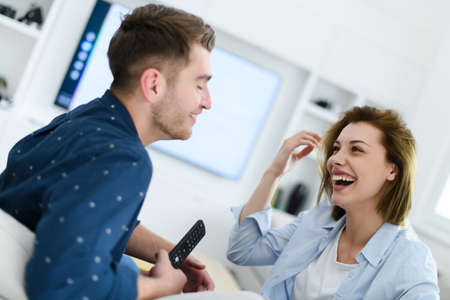 a young married couple enjoys sitting in the large living roomの写真素材