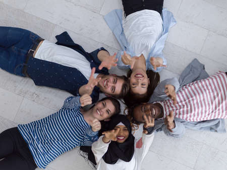 top view of a diverse group of people lying on the floor and symbolizing togethernessの写真素材