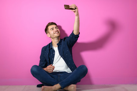 man sitting on the floor of the house and using the phone