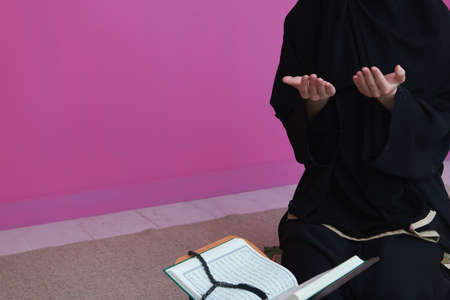 Middle eastern woman praying and reading the holy Quranの写真素材