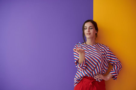 Portrait of happy smiling young beautiful woman in a presenting gesture with open palm