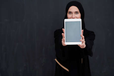 Young Arab businesswoman in traditional clothes or abaya holding tablet computerの写真素材