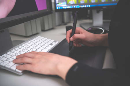 Female hands using keyboard and graphic tablet close upの写真素材
