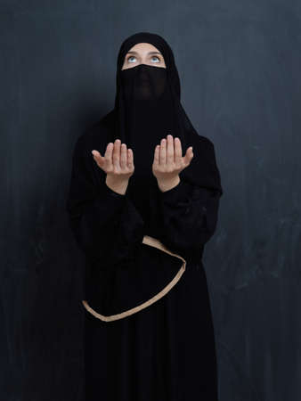 Portrait of young Muslim woman with niqab making duaの写真素材