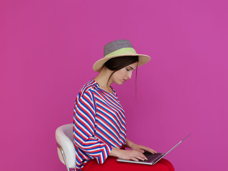 Portrait of young woman sitting on the chair and holding laptop on the lap
