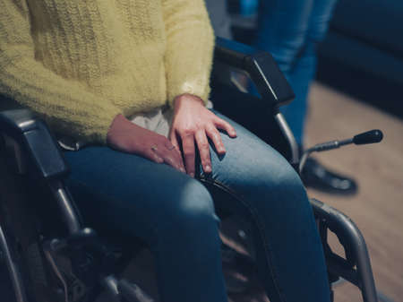 Sad and depressed disabled businesswoman in a wheelchair at the officeの写真素材