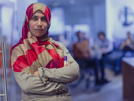 Muslim woman wearing hijab in office, Arabic business woman covered with headscarf smiling....