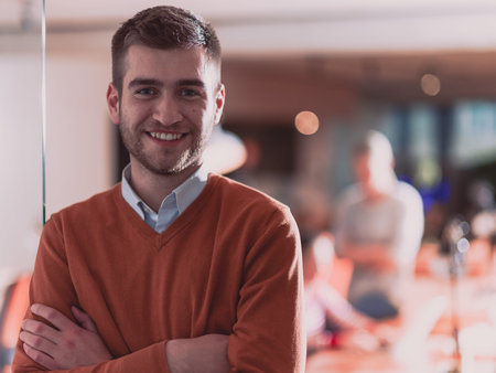 Handsome young business man standing confident in the office in front of his team