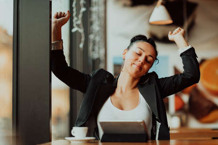 a latino woman sitting in a cafe on a break from workの写真素材